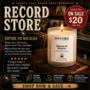 A promotional ad for B&B Candle Company's 'Record Store' scented soy wax candle. The candle is shown lit in a rustic, dark-themed setting with vinyl records and wooden textures.